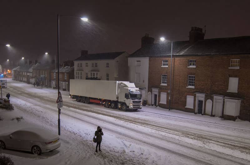 Large truck driving in snowy conditions